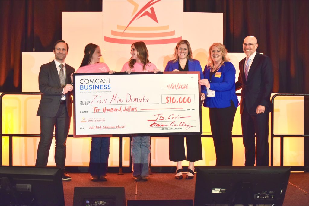 The winners of MCSB Michigan's Next Big Idea Pitch Competition Zoey and Lydia Heyn holding a giant check.
